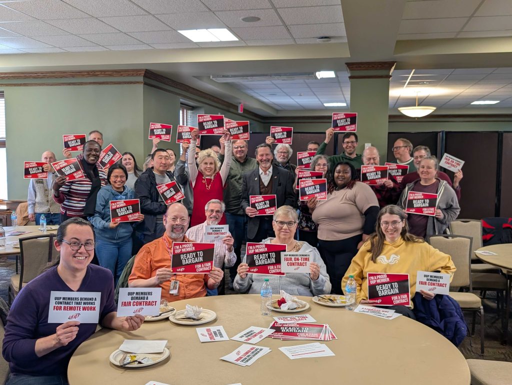 UUP Statewide President Fred Kowal (center) and Oneonta UUP Chapter members hold signs in support of a Fair, On-Time Contract.